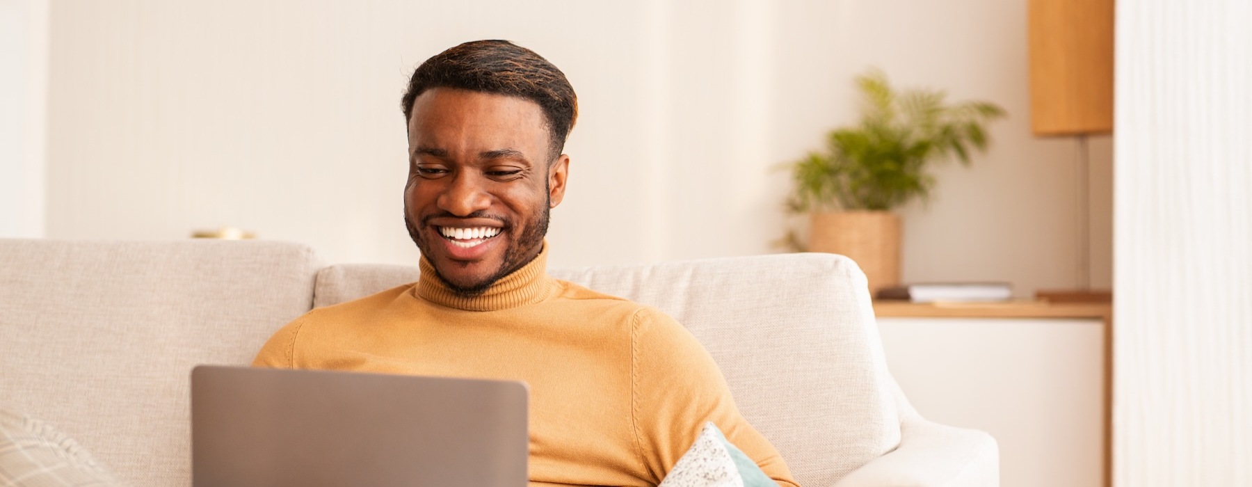 a man sitting on a couch with a laptop